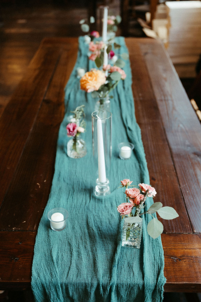 Colorful flowers, candlelight, and a teal runner at Kristen & Tommy's reception.
