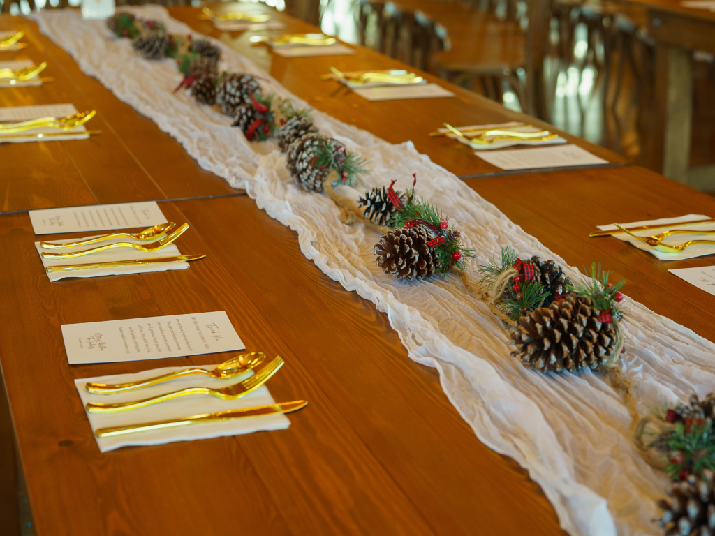 Winter greenery and pinecones at Roman & Sydney's barn reception.