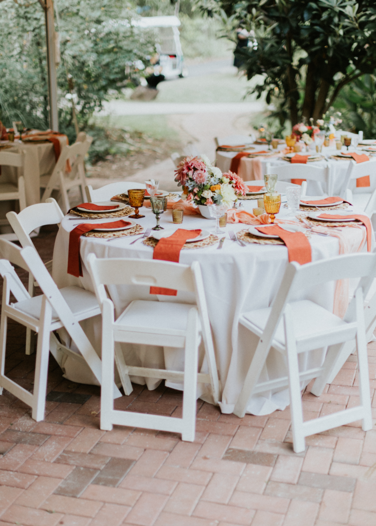 Coral napkins and colorful glassware at Hannah & Blakeley's tented reception.