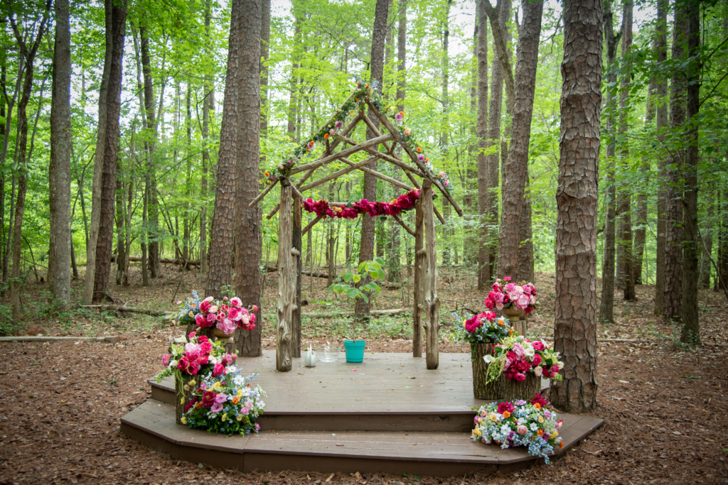 Bright flowers framed Daisy & Nathan's woodland ceremony space.